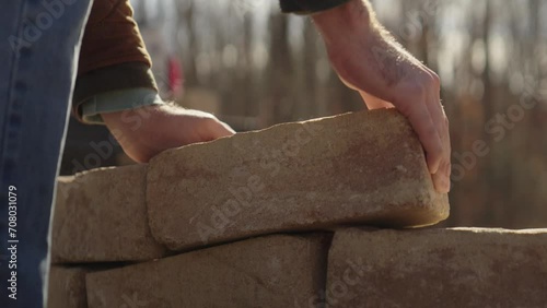 Man unloading bricks from a pickup truck and building an outdoor fire pit photo