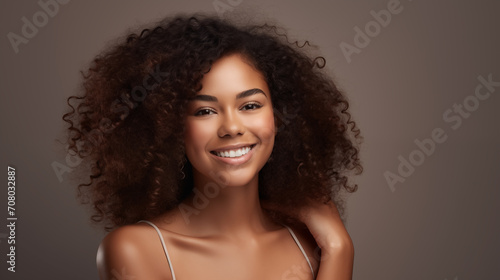 The image displays a young woman with a joyful expression and voluminous curly hair.