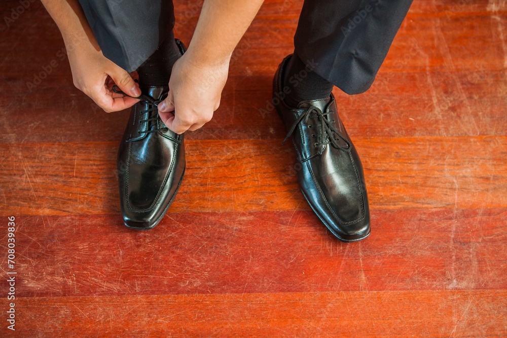 Man tying wedding shoes