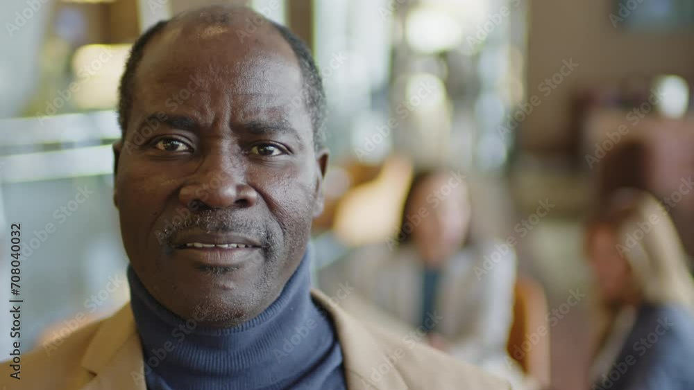 Portrait of mature African American businessman posing for camera in hotel lobby bar Portrait of mature African American businessman posing for camera in hotel lobby bar