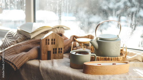 Cozy winter photo, stack of sweaters, book, tea and candle photo