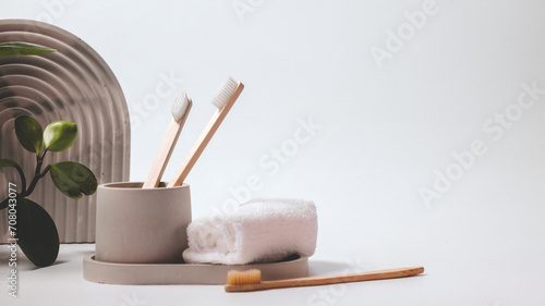 Bamboo toothbrushes in a stylish concrete glass on a white background