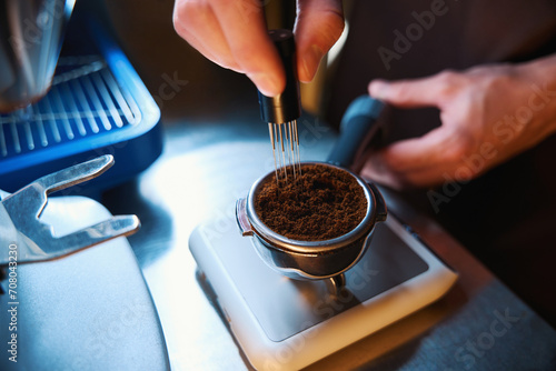 Barista hands leveling coffee in portafilter using powder distribution tool