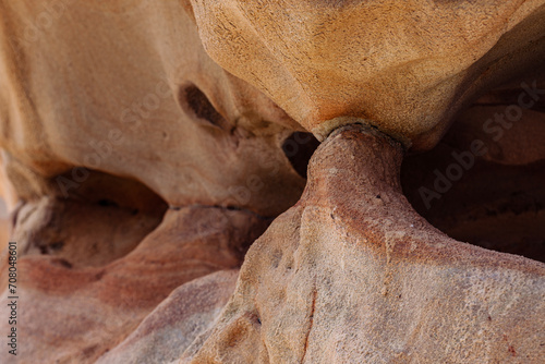 Geological detail of rocks in orange and ochre tones with abstract shapes in the cliffs