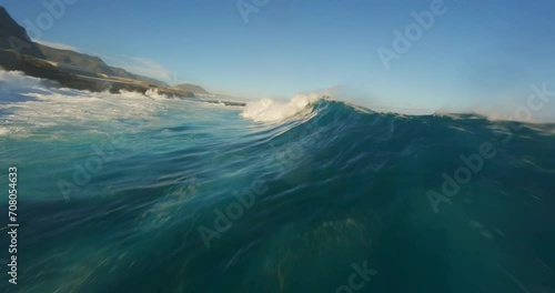 Aerial FPV drone footage of serene ocean waves and a majestic mountain landscape at sunrise, showcasing nature's beauty in dynamic, cinematic style