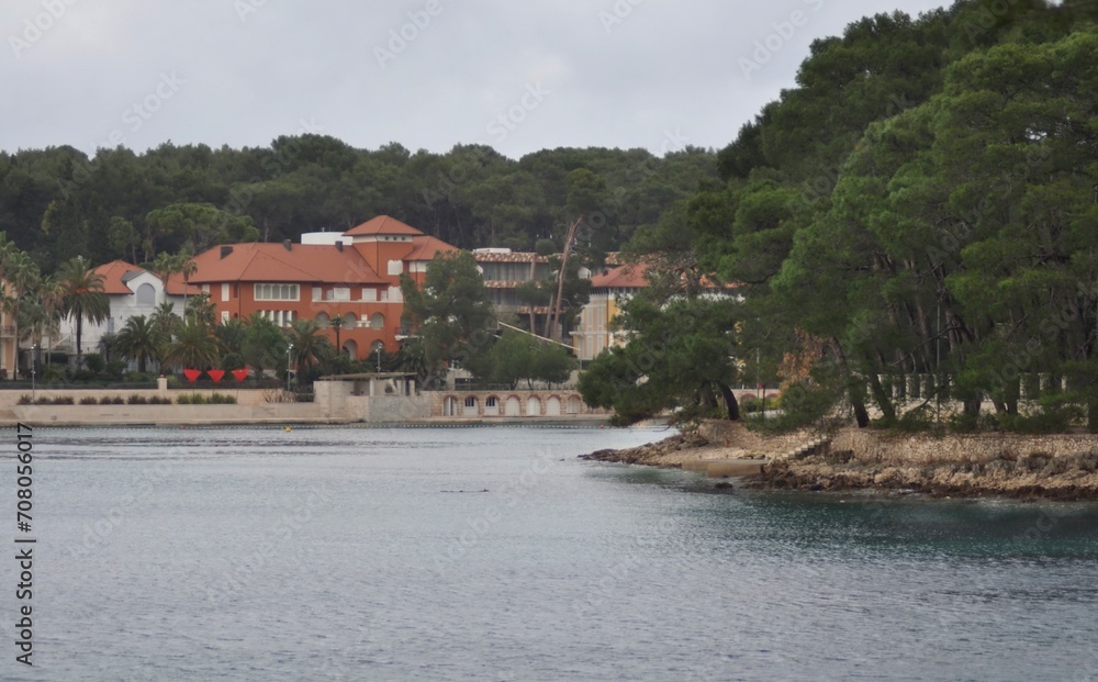 Beautiful boutique hotels by sea. Cikat, Island of Losinj, Croatia. Cikat forest park beach with trees and the blue sea . Beautiful boutique hotels by sea. Cikat, Island of Losinj, Croatia. Cikat forest park beach with trees and the blue sea .