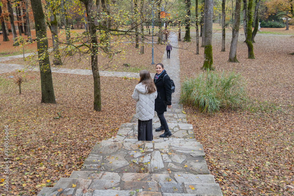 Fototapeta premium Peaceful scene of family enjoying autumn park, relaxing outdoors together.