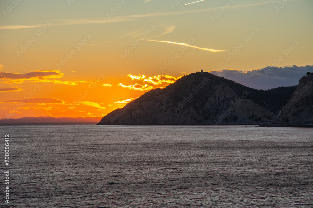 Orange sunset over the Mediterranean Sea seen from the Benidorm beach on Costa Blanca in Spain