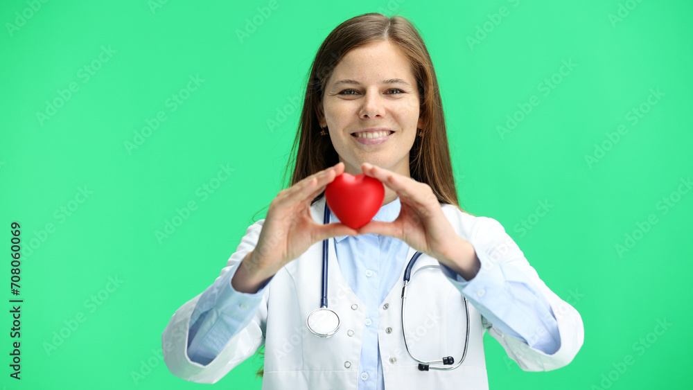 Female doctor, close-up, on a green background, shows a heart Female doctor, close-up, on a green background, shows a heart