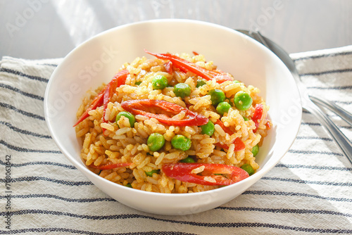 Spicy curry fried rice with sliced red chilli pepper and green peas. Healthy and dietary food. 