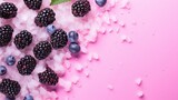A nutrition concept with a shot of juicy blueberries and blackberries on a rosy background in summertime and a healthy organic ripe seasonal berry for dessert.