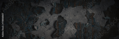 Dark wide panoramic background. Peeling paint on a concrete wall. Dark grunge texture of old cracked flaking paint. Weathered rough painted surface. Patterns of cracks. Darkness background for design. photo