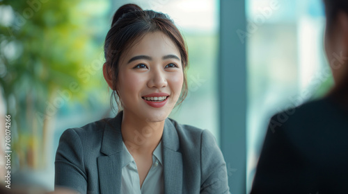 Young Chinese Woman in Business Dress at Job Interview, Smiling in Professional Office Setting, Engaging Positive Interaction with HR Interviewer, Successful Meeting, Formal Agreement Corporate 