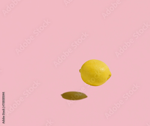 An isolated lemon floating against the pastel pink background. Copy space, minimal fruit concept. Healthy, balanced diet.