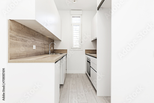 Small kitchen furnished in the absence of appliances with furniture on both sides