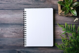 Spiral Notebook with White Pages and Green Plants on Wooden Texture