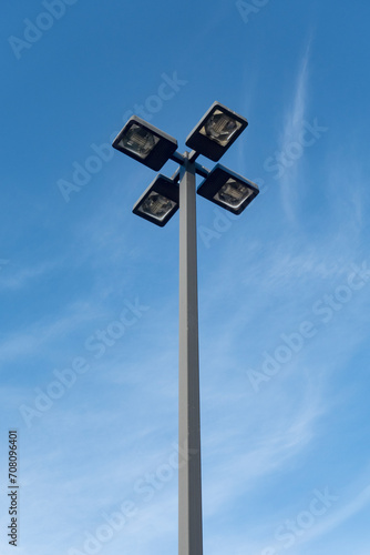 Outdoor parking lot light fixture against blue sky