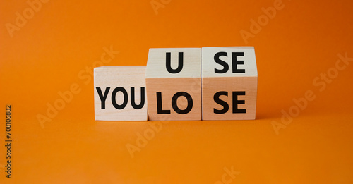 You use or lose symbol. Turned wooden cubes with words You lose or You use. Beautiful orange background. Business and You use or lose concept. Copy space