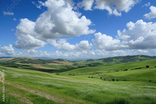Fluffy white clouds casting soft shadows over rolling hills.