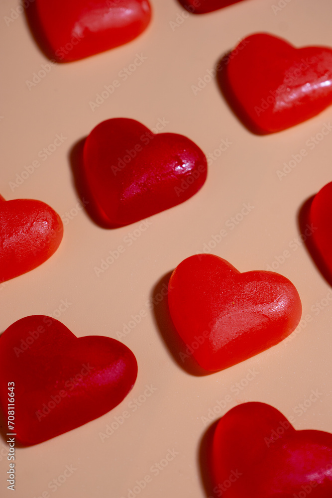 red heart shaped candies laying in a grid, tilted view