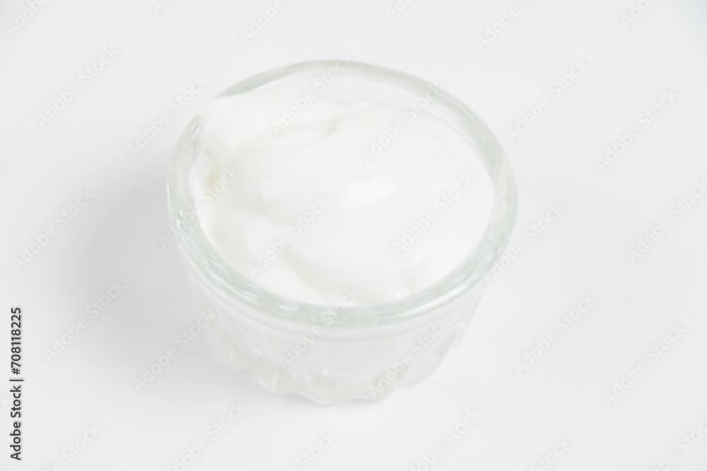 Sour cream in a glass saucer on a white background Sour cream in a glass saucer on a white background
