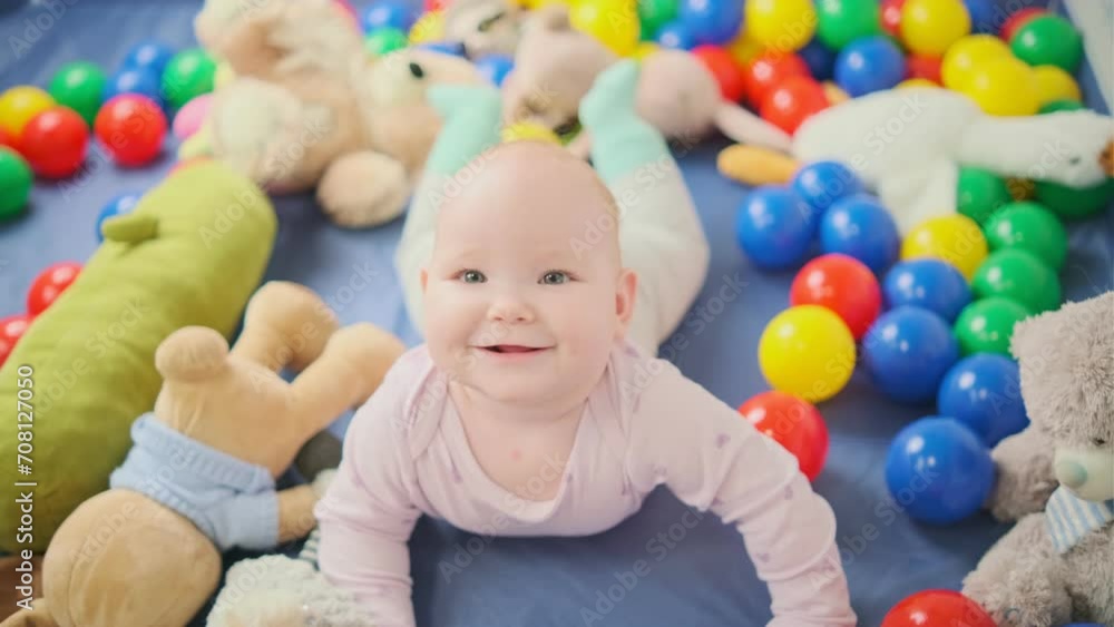 Cute baby girl playing with colorful toys in the nursery at home Cute baby girl playing with colorful toys in the nursery at home