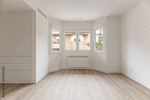 A newly renovated room with white wooden cabinets, a large gallery with white aluminum windows