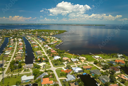 Bild auf Leinwand Aerial view of residential suburbs with private homes located on gulf coast near wildlife wetlands with green vegetation on sea shore