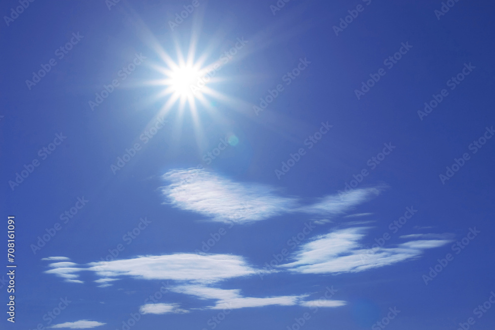 sun in blue sky with some white lenticular clouds sun in blue sky with some white lenticular clouds