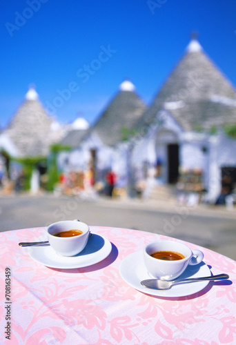 closeup of two cups of Espresso on a table, with empty street out of focus in background in Alberobello in preseason, Alberobello, Apulia, Italy, Europe photo