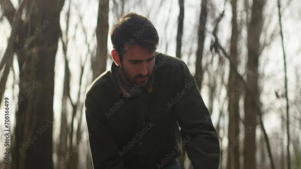 Man in the woods cutting wood with a chainsaw Man in the woods cutting wood with a chainsaw