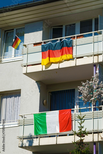 national flags of Germany and Italy fixed at balcony railings of a Revenue House, while soccer world championship 2006, Munich, Bavaria, Germany