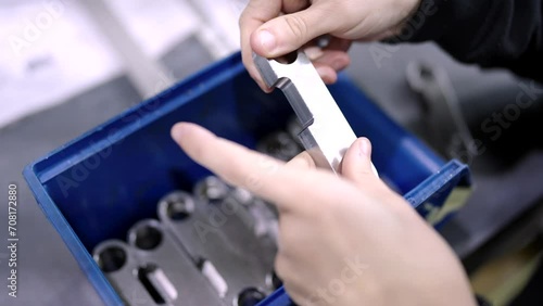 Video with close-up of the hands of an engineer checking the quality of small metal pieces in a cnc modern factory