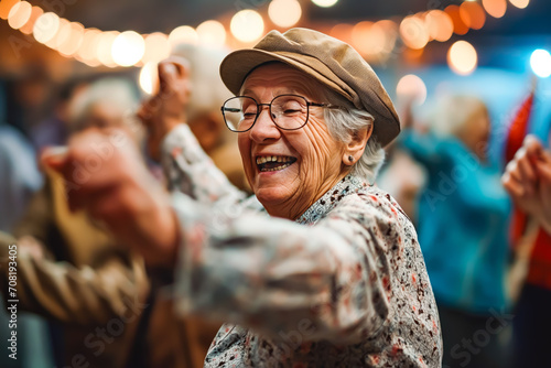 Smiley seniors dancing and having fun celebrating birthday in nursing home, elderly people enjoying a lively social activity gathering.