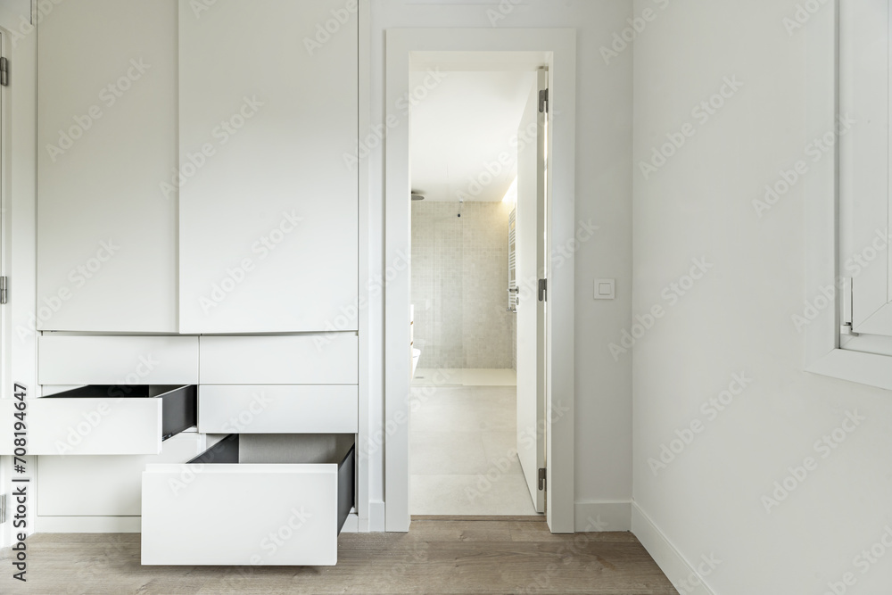 dressing room in an empty room with built-in wardrobes with drawers and open doors dressing room in an empty room with built-in wardrobes with drawers and open doors