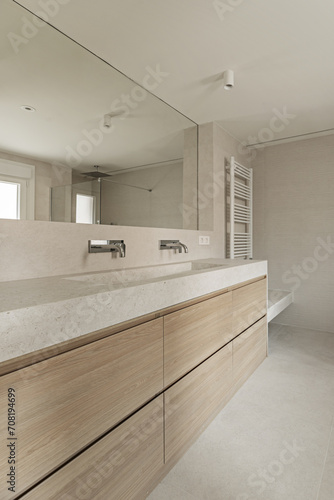 Modern design bathroom with cream marble sink on wooden cabinet with drawers
