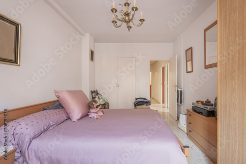 An economical bedroom with a double bed with a fuchsia bedspread