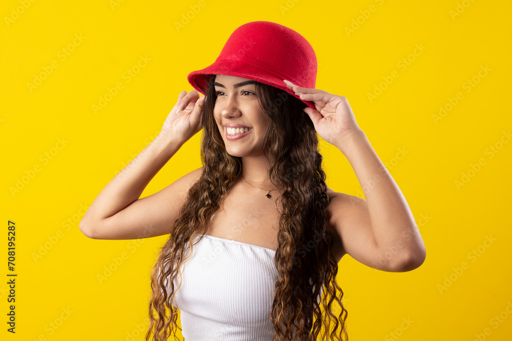 young woman, wearing white dress and a red hat, smiling on a yellow background young woman, wearing white dress and a red hat, smiling on a yellow background