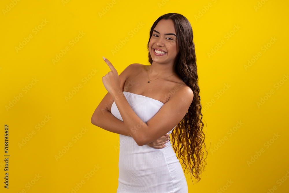 Happy young woman wearing a white dress on a yellow background Happy young woman wearing a white dress on a yellow background