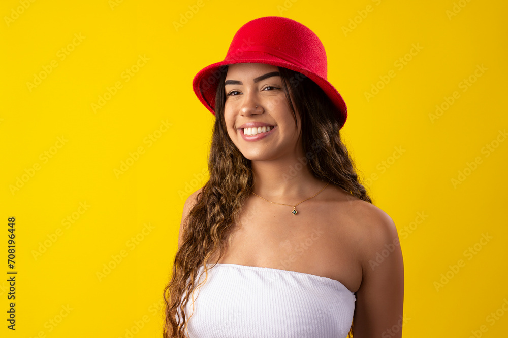 Happy young woman wearing a white dress and a worm hat on a yellow background Happy young woman wearing a white dress and a worm hat on a yellow background