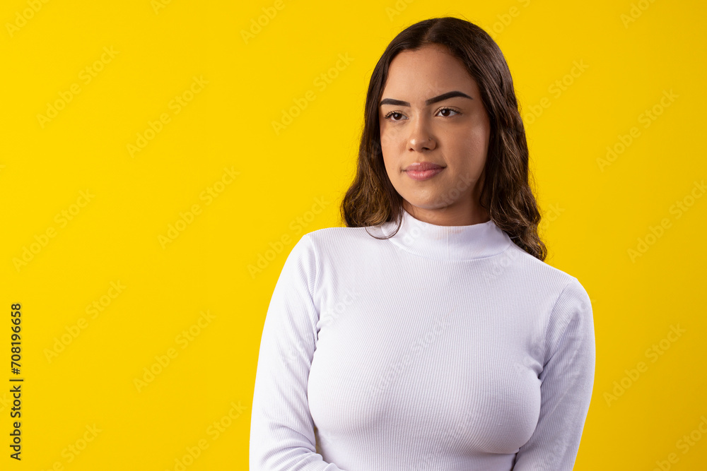 Young, happy woman wearing a white blouse, happy on yellow background Young, happy woman wearing a white blouse, happy on yellow background