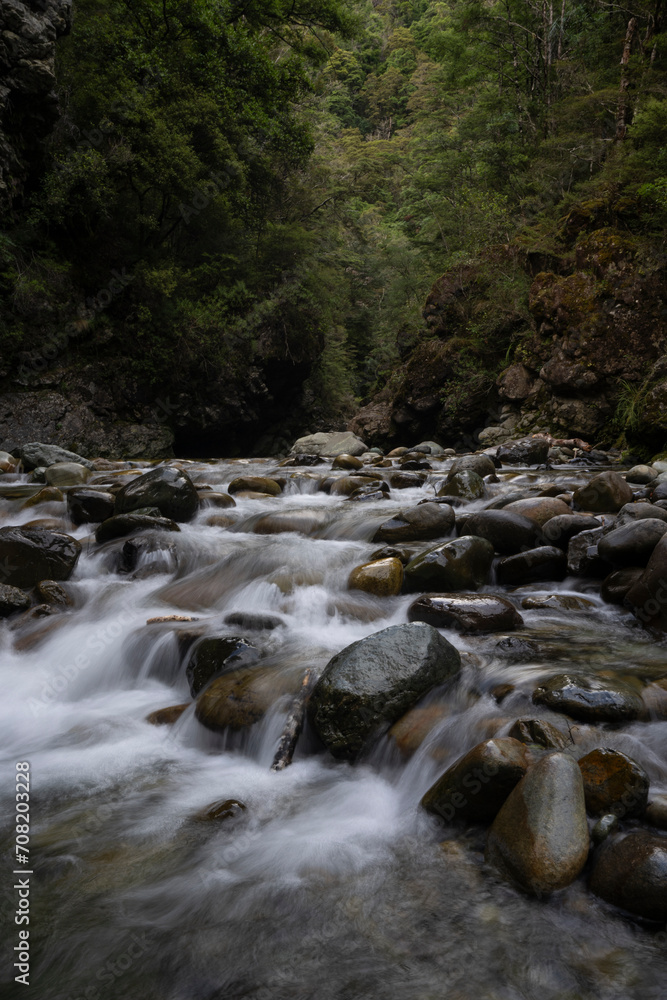 Vertical waterfall background with rocks and trees in a forest Vertical waterfall background with rocks and trees in a forest