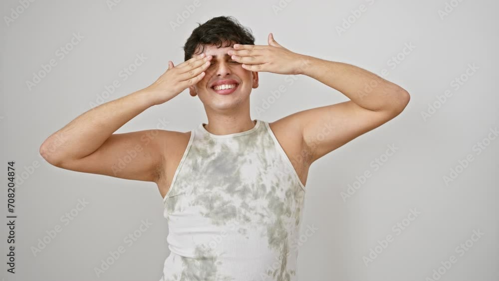 Cheerful young man, eyes concealed with hands, playfully posing on a white, isolated background. wearing sleeveless t-shirt, appearing blissful and amusing with a hint of mystery. Cheerful young man, eyes concealed with hands, playfully posing on a white, isolated background. wearing sleeveless t-shirt, appearing blissful and amusing with a hint of mystery.
