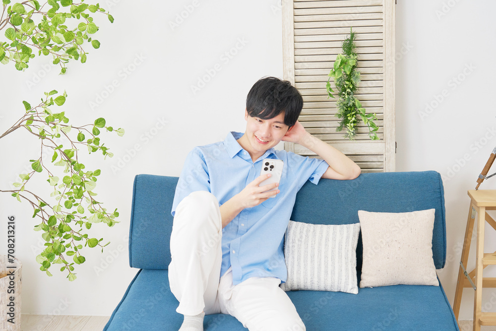 自宅でスマートフォンを使う男性 自宅でスマートフォンを使う男性