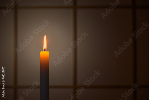 和室の障子の前で静かに燃える蝋燭