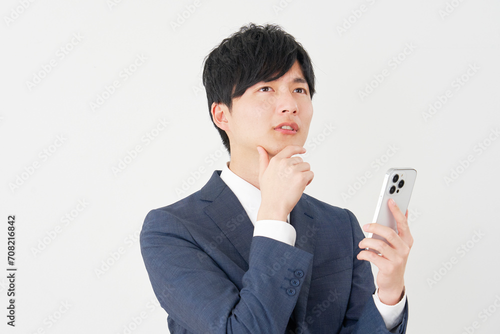 スマートフォンを持って考えるビジネスマン　白背景