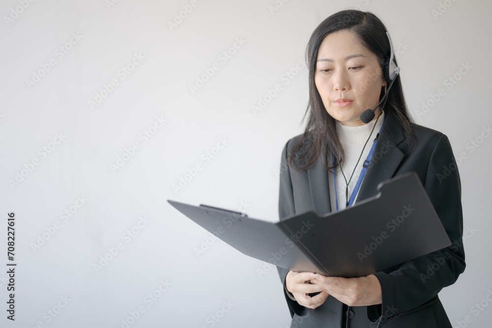 書面を確認するインカムの女性 書面を確認するインカムの女性