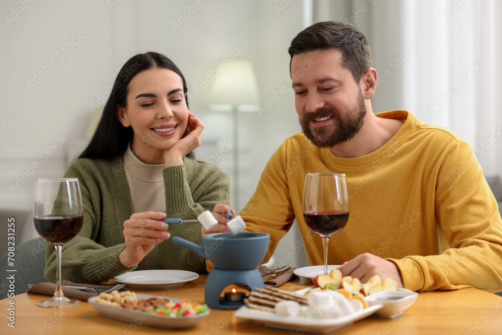 Affectionate couple enjoying fondue during romantic date at home