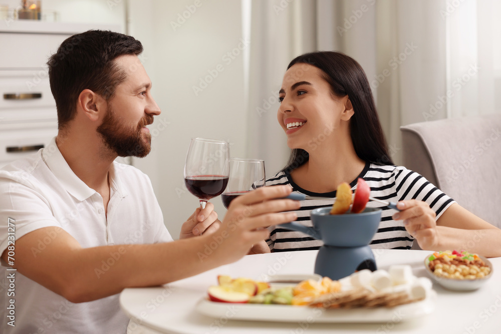 Affectionate couple enjoying chocolate fondue during romantic date at home Affectionate couple enjoying chocolate fondue during romantic date at home