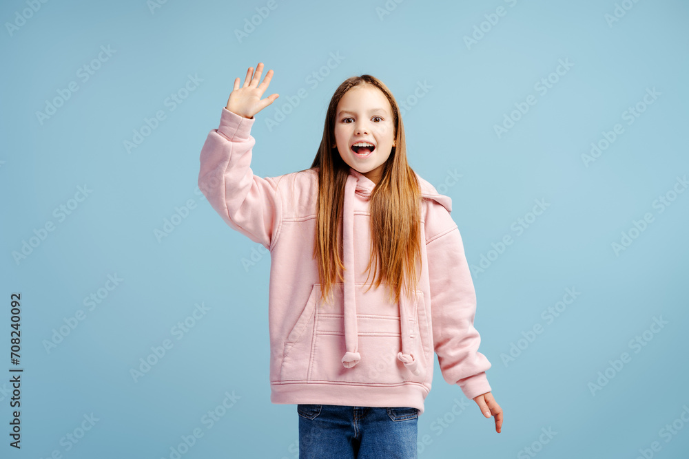 Portrait of excited little girl with open mouth looking at camera and waving hand Portrait of excited little girl with open mouth looking at camera and waving hand